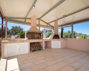 Kalopsia Luxury Apartment Near Chania في مدينة خانيا: مطبخ في الهواء الطلق مع فرن بيتزا على الفناء