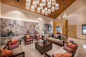 a living room with couches and a painting on the wall at Ananta Spa & Resort Jaipur in Jaipur