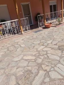 a stone patio with a fence in front of a building at Sofia's house in Kilkís