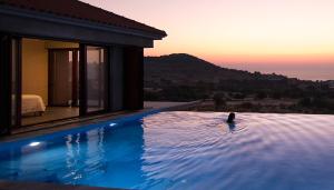 eine Person, die in einem Schwimmbad in einem Haus schwimmt in der Unterkunft Villa Molivos Views in Mythimna