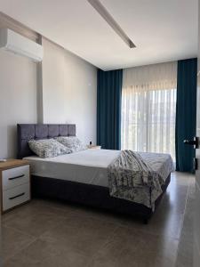 a bedroom with a large bed with blue curtains at Villa Ögreten in Aydın +20 photos