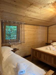 a bedroom with two beds in a log cabin at Cabana de sub Nuc in Ocna Şugatag