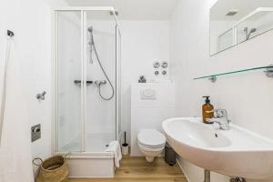 a white bathroom with a shower and a sink at Ruhige und stilvolle Wohnung am Clara-Zetkin-Park in Leipzig