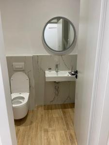 a bathroom with a toilet and a sink and a mirror at Florida Rooms in Vlorë