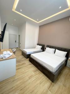 a hotel room with two beds and a television at Florida Rooms in Vlorë +8 photos