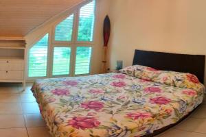a bedroom with a bed with a floral bedspread at Villa Matthy Casa con giardino fronte fiume possibile nuotare in Gebenstorf +47 photos