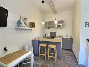 Una cocina y un comedor con mesa y sillas. en Studio vieil Antibes et mezzanine proche de la mer, en Antibes