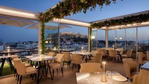 アテネにあるElia Ermou Athens Hotelの市街の景色を望むレストラン(テーブル、椅子付)