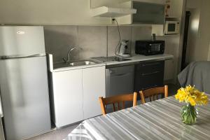 a kitchen with a refrigerator and a table with yellow flowers at Gîte à PESTEL in Lespéron