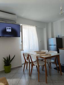 a dining room with a white table and chairs at Thama Poros-Nostos in Poros