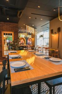 a dining room with a long table with plates and utensils at ibis Santiago Las Condes Manquehue in Santiago