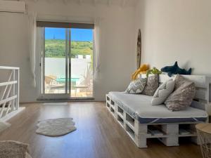 a living room with a couch and a balcony at Cais Inn in Horta