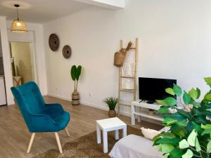 a living room with a blue chair and a tv at Cais Inn in Horta