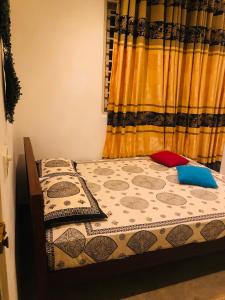 Una cama con dos almohadas encima en un dormitorio. en Suriya Accommdation, en Matara