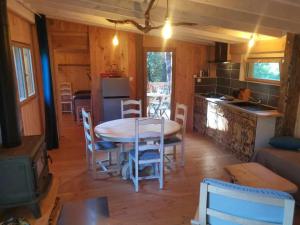 a kitchen and dining room with a table and chairs at Gîte nature L'éveil de la forêt in Vitrac-sur-Montane +28 photos