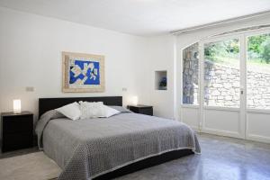 biała sypialnia z łóżkiem i oknem w obiekcie Villa Il Sole w mieście Cortona +23 zdjęcia