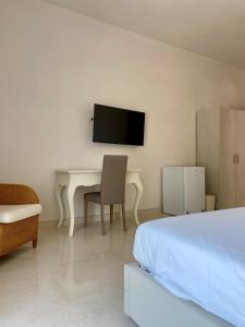 a bedroom with a bed and a desk and a tv at Casa del Parco - Salento Homes in Melendugno