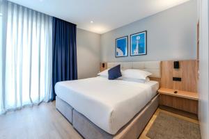 a bedroom with a large bed and a large window at Hotel A'mare in Zadar