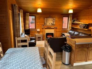 a living room with a couch and a fireplace at Lomond View Lodge in Glasgow