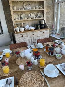 a wooden table with plates and bowls on it at Thropton Demesne Farmhouse B&B in Rothbury +24 photos