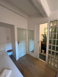 a white room with a bedroom with a door and a table at Fishermans House Saint Tropez in Saint-Tropez +117 photos