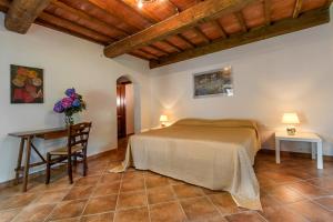 a bedroom with a bed and a table with a desk at Fattoria Javello - Agriturismo La Casaccia in Montemurlo