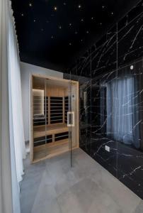 a bathroom with black marble walls and a window at Bounce Belgrade Apartment in Vračar (historical) +6 photos
