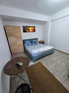 a small bedroom with a bed and a table at Vila VECAS in Eforie Nord +11 photos