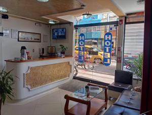 a lobby with a bar and a view of a car dealership at Hotel Buenaventura in Pasto