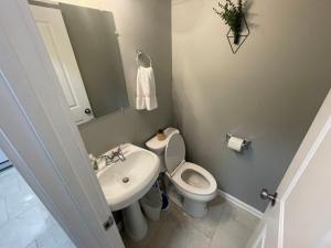 a bathroom with a white toilet and a sink at The Yale Townhouse 2 - 2BR in Columbus