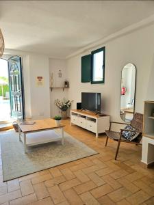 a living room with a table and a tv at Casa Aventura in Boliqueime