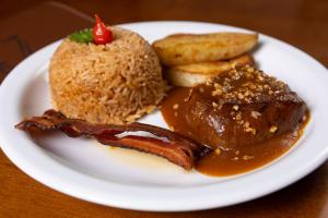 a plate of food with meat and bacon and bread at RILL HOTEL BY UCHÔA in Teresina