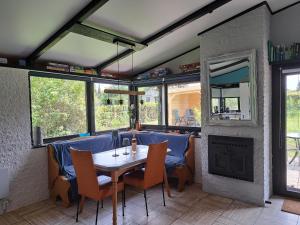 a dining room with a table and a fireplace at Ferienhaus Waldidyll in Gerolstein