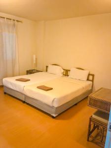 a bedroom with a large white bed with two pillows at คอนโดบ้านทะเลสำราญ in Cha Am