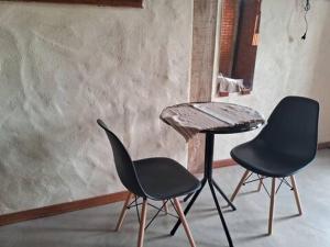 two chairs and a table in a room at Suite Pedro - Casa Tapera Nova in Conceição da Ibitipoca