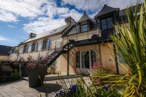 an exterior view of a house with flowers at Le quartier d'hiver, maison d'hôtes in Cléden-Cap-Sizun