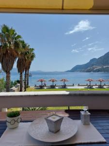a table on a balcony with a view of the ocean at MANTZARIS APPARTMENTS in Ancient Epidauros