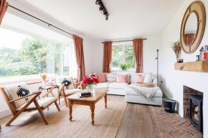 a living room with a white couch and a table at Idyllic 3 Bed Country Cottage in West Wittering