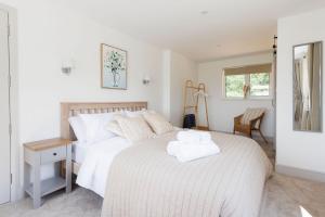a bedroom with a bed with a towel on it at Idyllic 3 Bed Country Cottage in West Wittering