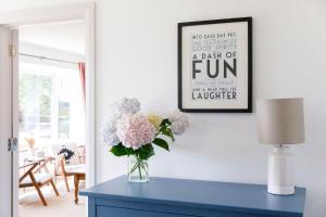 a vase of flowers on a blue table in a living room at Idyllic 3 Bed Country Cottage in West Wittering