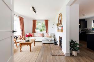 a living room with a white couch and a table at Idyllic 3 Bed Country Cottage in West Wittering