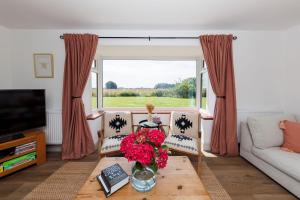 a living room with a couch and a table with flowers at Idyllic 3 Bed Country Cottage in West Wittering +48 photos