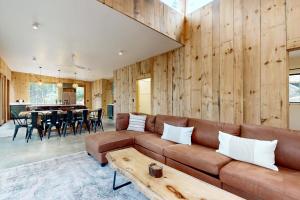 a living room with a brown couch and a table at Hideaway House in Hope
