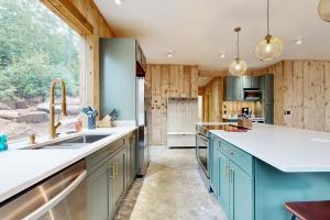 a kitchen with blue cabinets and a large window at Hideaway House in Hope +17 photos