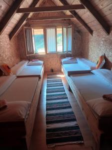 a room with four beds in it with windows at Dulović - KATUN POTOCI in Kolašin