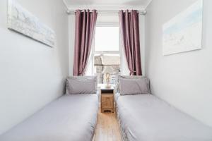 two beds in a room with a window at Beach Way in Berwick-Upon-Tweed +21 photos