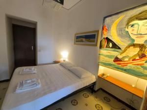 a bedroom with a bed with a painting on the wall at Villa il Glicine in Vulcano