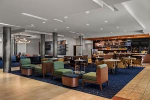 a lobby with tables and chairs and a bar at Courtyard by Marriott Evansville East in Evansville