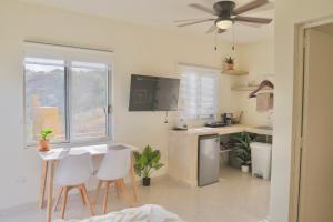 a kitchen with a table and white chairs and a ceiling fan at Estudio con vista al mar in San José del Cabo