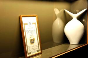 two vases are sitting on a shelf with a frame at Edi Hotel in Sofia